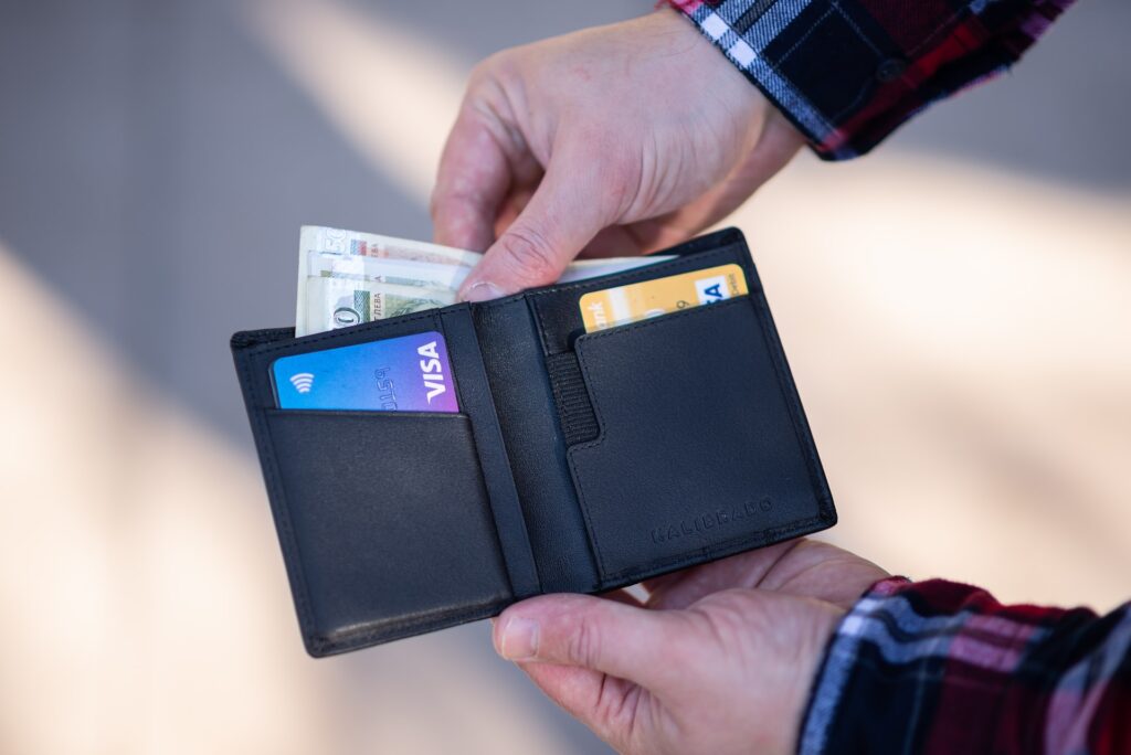 image of man taking money out of wallet to show that getting a prenup protects you from your partner's debt