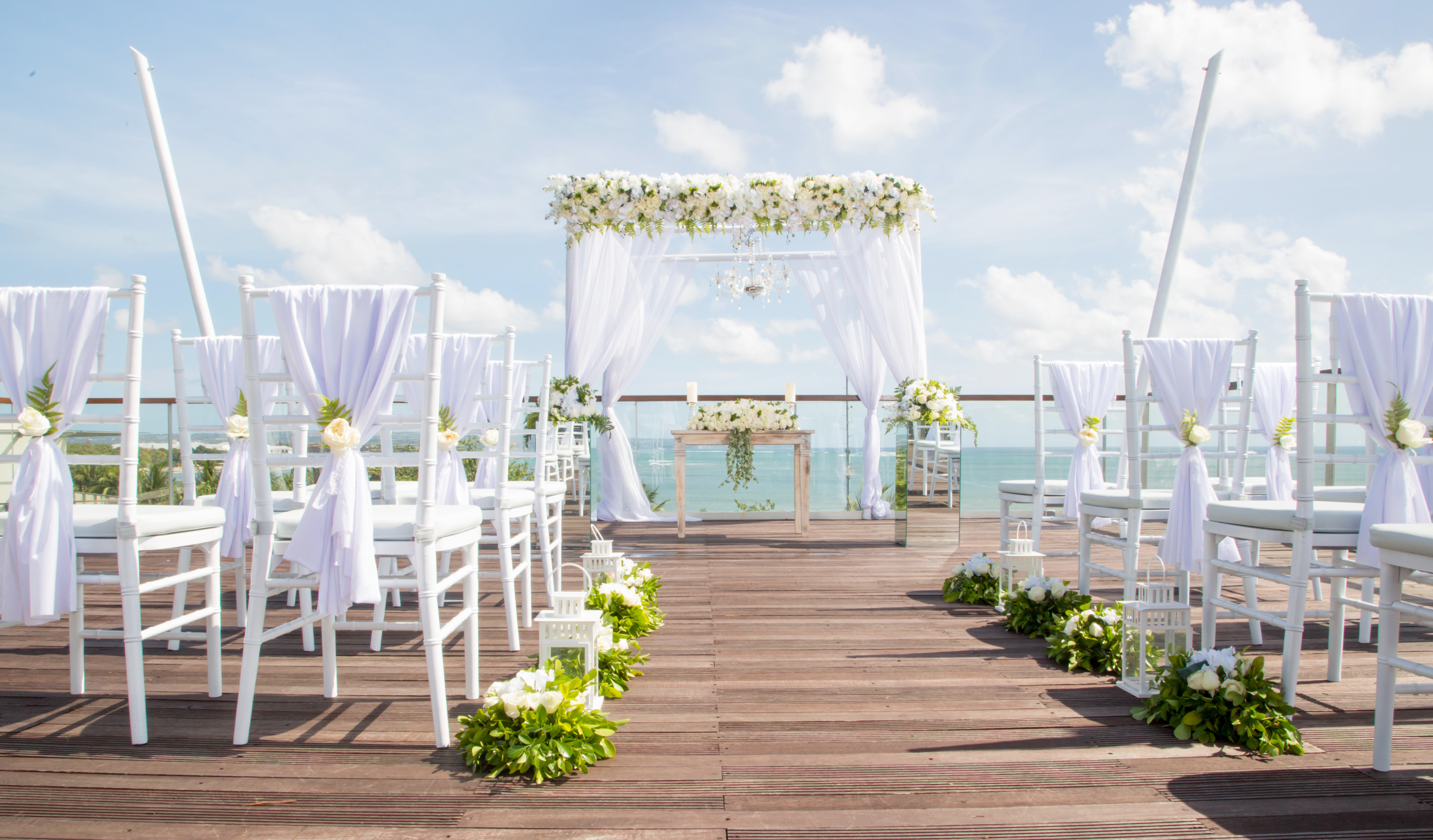 Rows of chairs set up for a tropical seaside wedding ceremony as part of the 2023 wedding trend for destination weddings