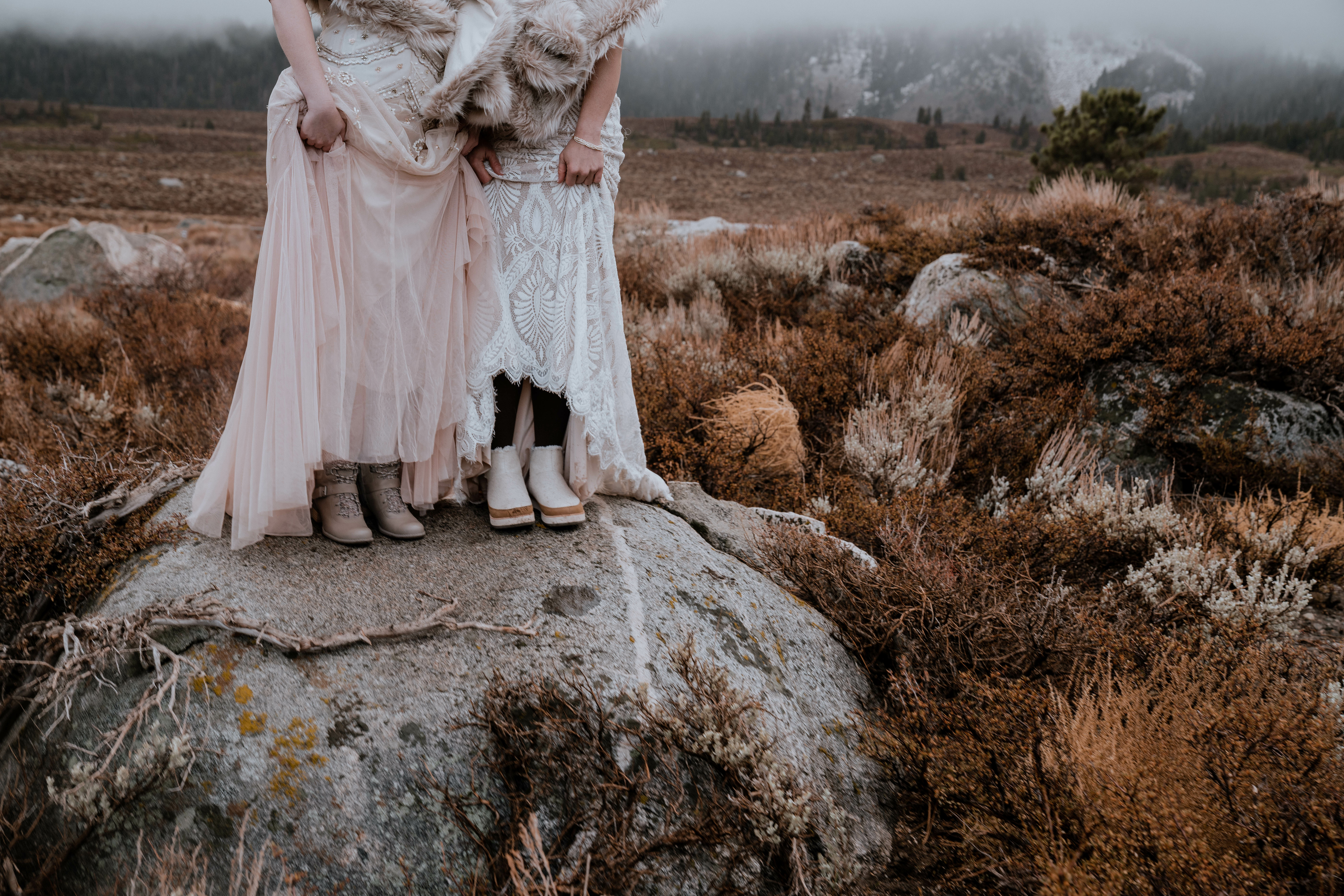 Two women in winter wedding dresses wearing boots for a winter wedding