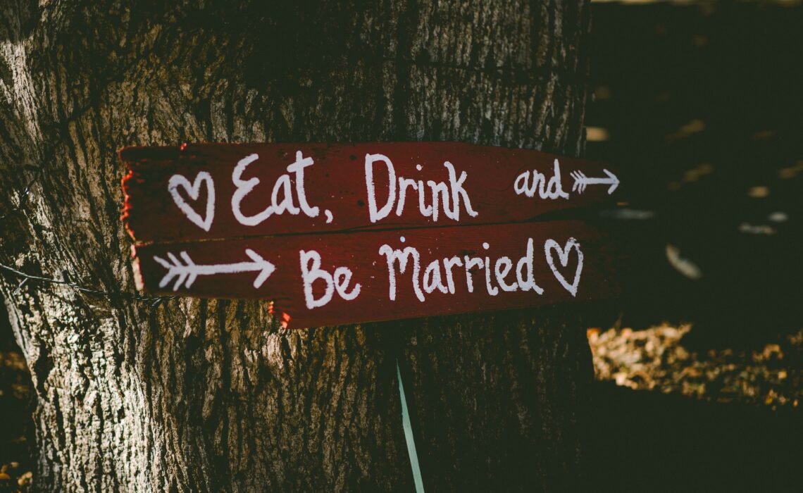 Sign at a wedding reception reading quote eat, drink and be married end quote