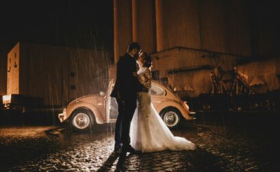 Bride and groom kissing in the rain on their wedding day