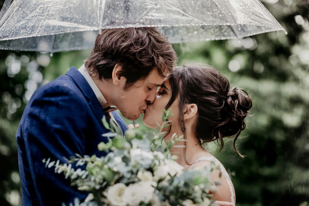 Wedding couple under an umbrella in the rain