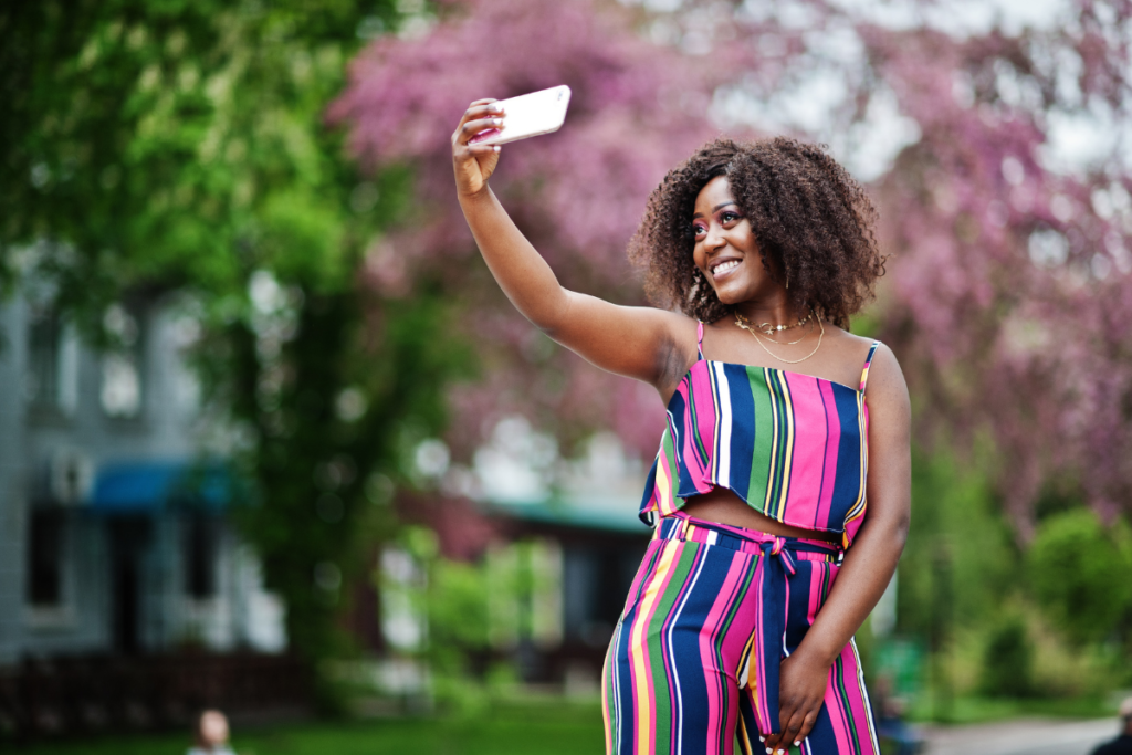 Woman taking a selfie wearing a colorful jumpsuit.
