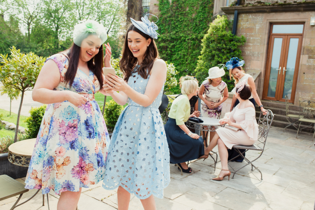 Female guests wearing pastel dresses and fascinators