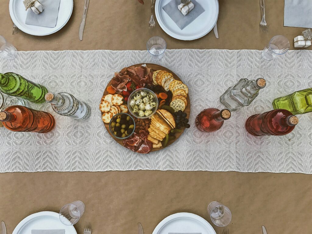 Dining table set for brunch party with brown wrapping paper, plates, and charcuterie