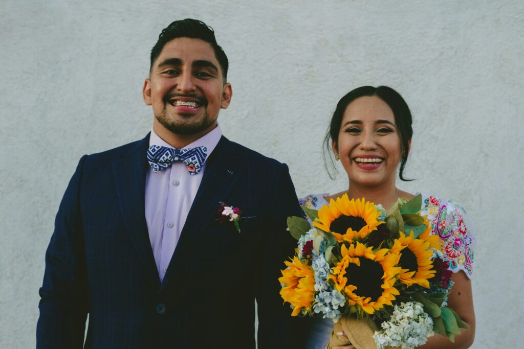 Bride holding a colorful bouquet with her groom