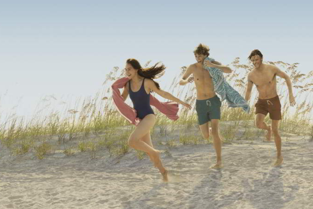The cast of the Summer I Turned Pretty running on the beach