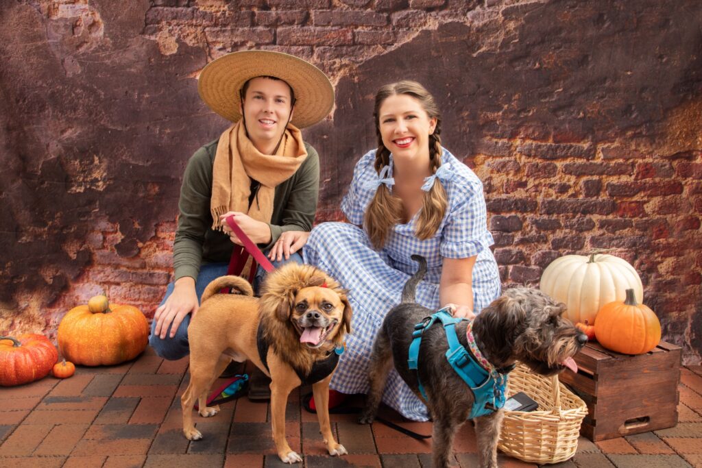 Man and woman dressed in Halloween costumes with their dogs