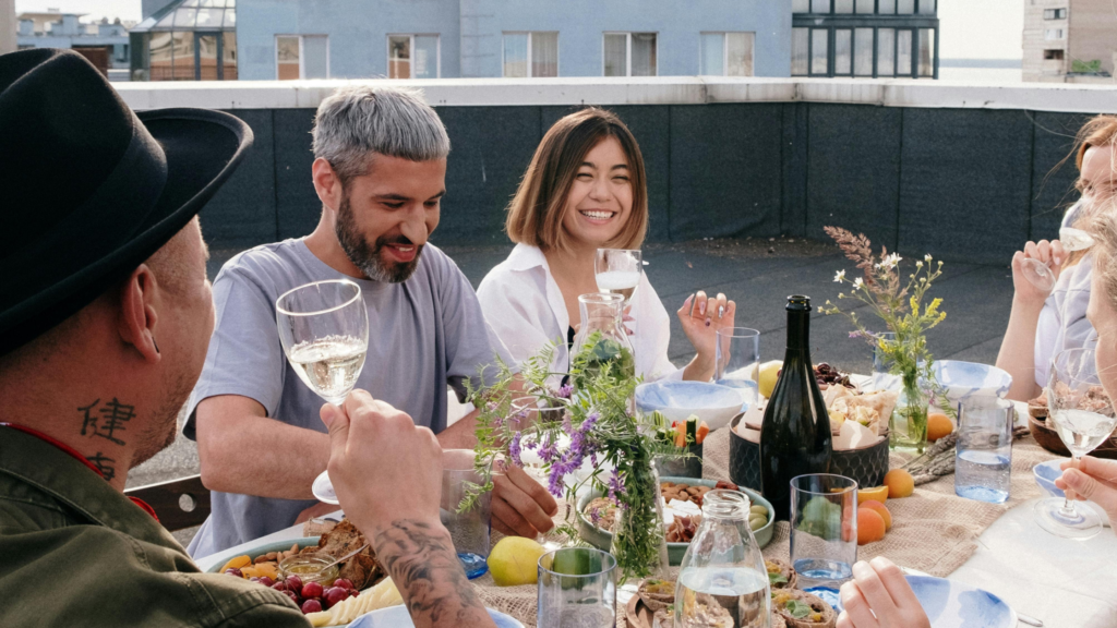 Group of men and women enjoying food and drinks on a rooftop