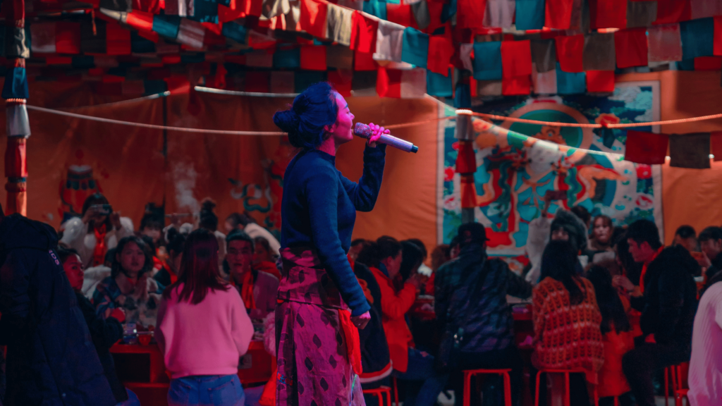 Woman speaking into a microphone at a crowded event