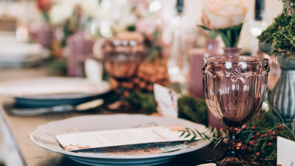 Wedding table with colorful goblet glasses, plates, and flowers