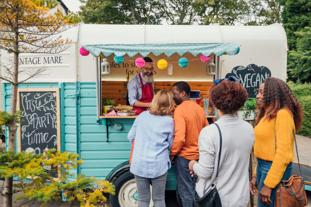 Men and women waiting in line at a food truck
