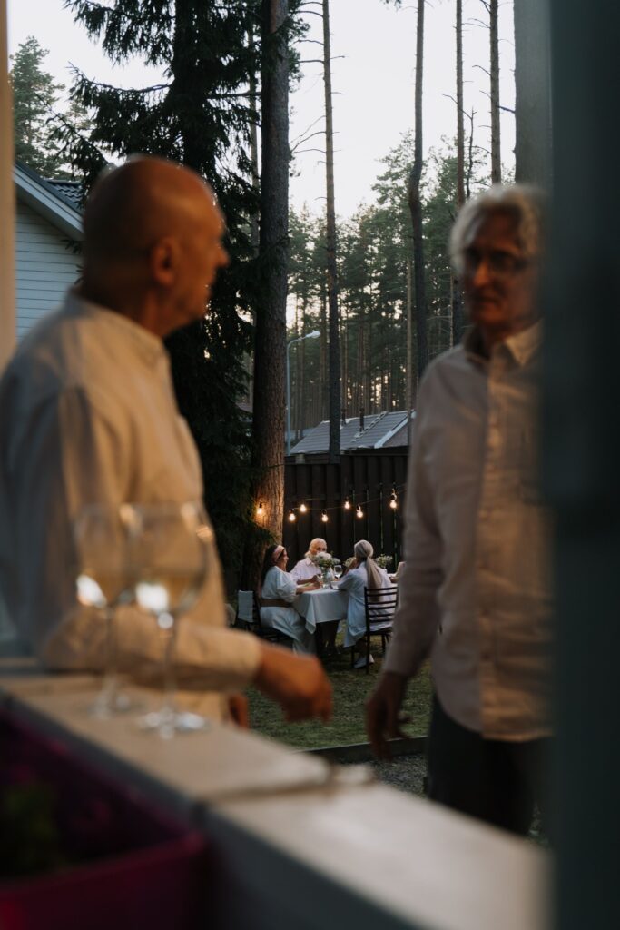 Two men talking at an outdoor party in the woods